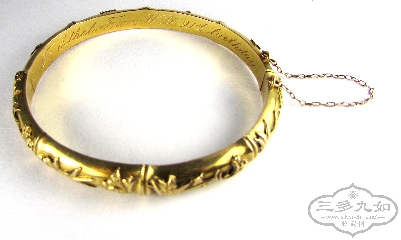 a gold bangle with applied bamboo leaves and inscription.jpg